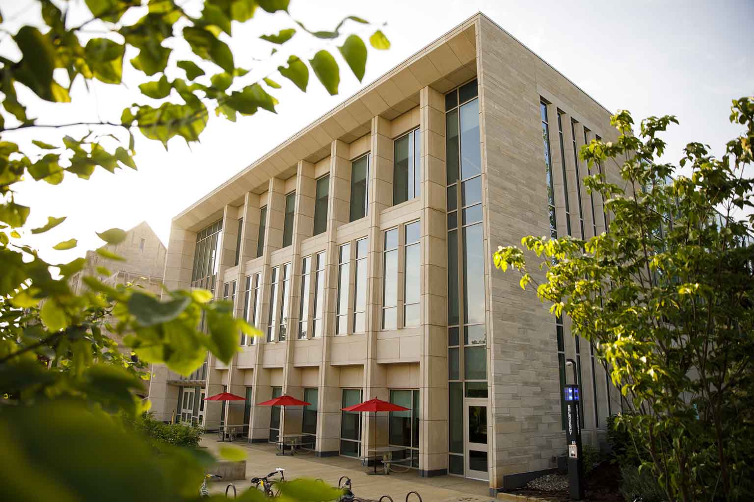 Front of building, tables, sun umbrellas.