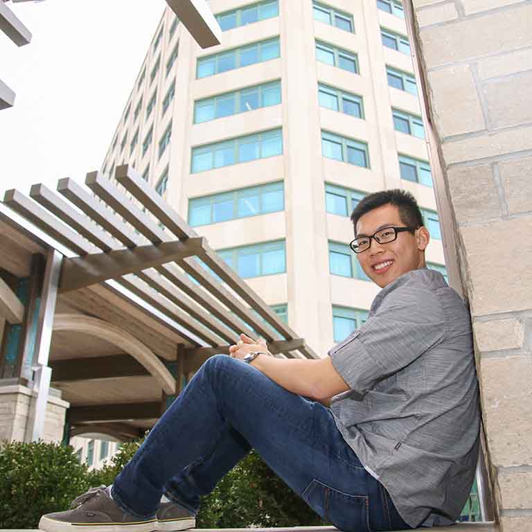 Student sitting on stone ledge